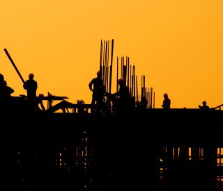 Construction workers at sunset.